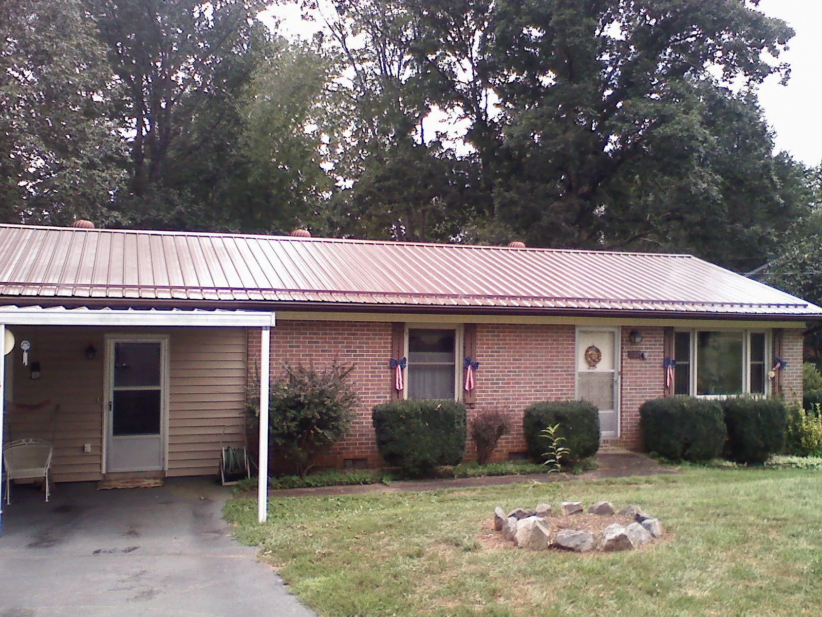 Bronze metal roof and carport on a brick ranch home — Roof Repair work by our crew in Herscher